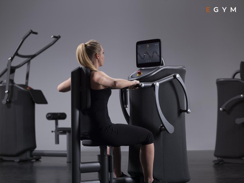 Frau trainiert an der EGym Brustpresse